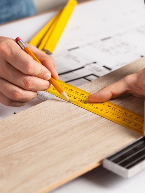 Carpenter Measuring A Wooden Plank