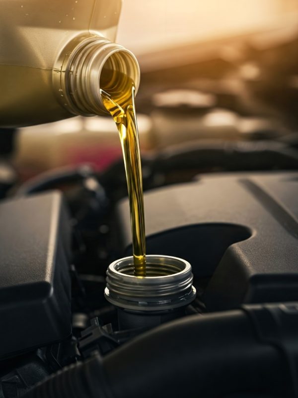 Engine oil being poured into a car engine. Close-up of engine oil being poured into a car engine.