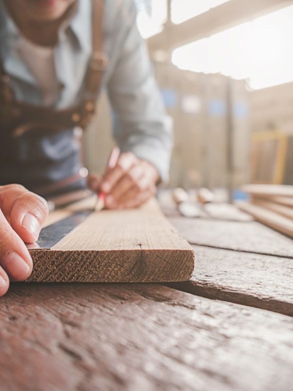 Carpenter working with equipment on wooden table in carpentry shop. woman works in a carpentry shop.