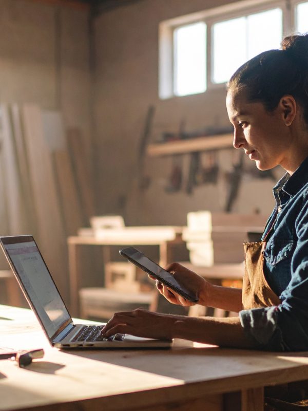 Firefly_handwerker, der an einem schreibtisch sitzt und modernen laptop was checkt, iphone un 417661
